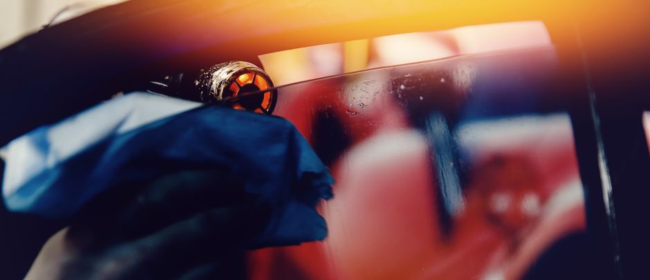 mechanic using a heat gun to tint vehicle window